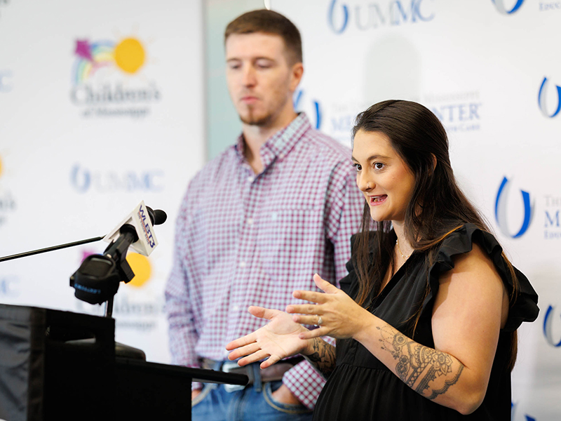 Ashley Meyers speaks to news media as husband Tyler Meyers looks on.